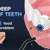 A close-up of a pink gum model showing teeth and food debris being cleaned by a water flosser.