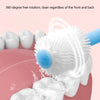 A white silicone baby toothbrush is shown rotating freely, cleaning teeth on a pink surface.