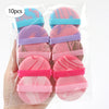 A pack of 10 pink and blue beauty puffs with purple accents inside a clear plastic bag