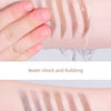 Gros plan d'une main appliquant des traits à l'arc à sourcils avec un crayon waterproof sur la peau.