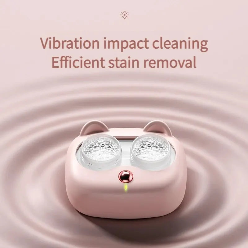 A pink high-frequency vibration cleaning case with two removable lens covers is shown against a soft background.