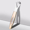 Raspador de lengua de acero inoxidable con mango de oro rosa sobre fondo gris claro.