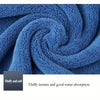A close-up of blue microfiber cleaning towels tightly rolled into a swirl, highlighting their fluffy texture and water absorp