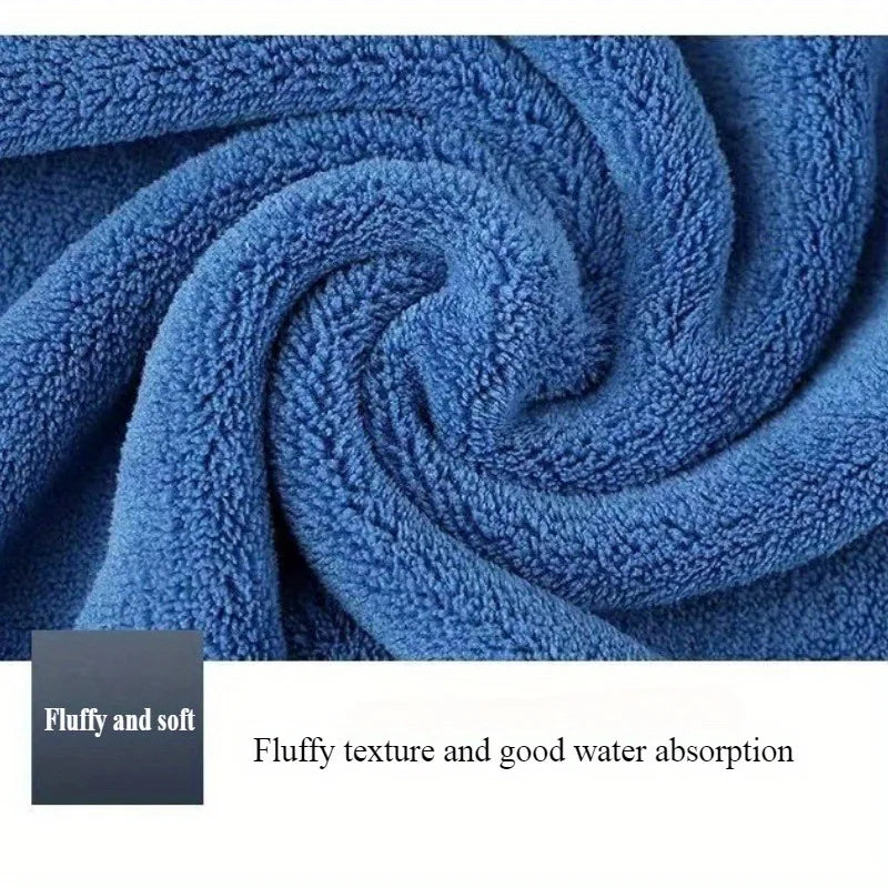 A close-up of blue microfiber cleaning towels tightly rolled into a swirl, highlighting their fluffy texture and water absorp
