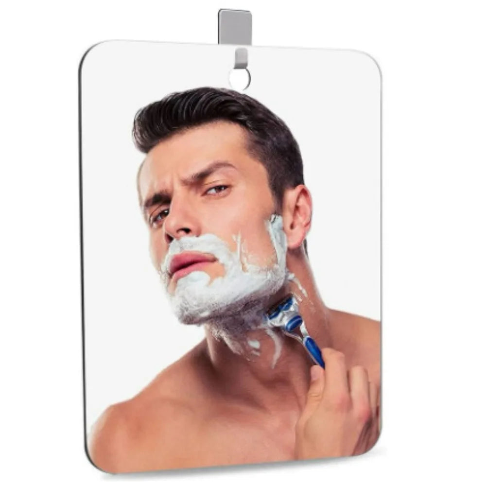Un homme se rase le visage avec de la mousse blanche sur un miroir de vanité en acrylique sans buée.