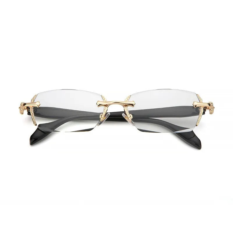A pair of retro frameless reading glasses with thin gold-toned metal frames and clear lenses.
