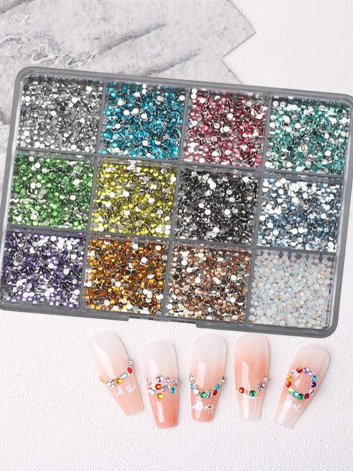Un plateau rectangulaire de strass et d'outils pour décorer les ongles.