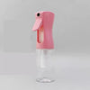 A pink spray bottle with a hinged cap is shown against a light gray background.