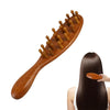 Peine de madera para el cuero cabelludo y el cabello con dientes redondeados, junto a el cabello oscuro de una persona.