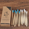Une boîte en bois contient dix brosses à dents en bambou pour adultes.