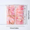 Una caja de plástico transparente contiene un set de uñas postizas de gel tridimensional rosa y blanco.