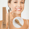 A woman holds a disposable bamboo toothbrush next to its packaging and shows a close-up of the brush head.