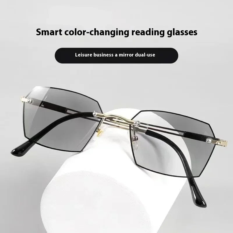A pair of black reading glasses with a gold frame resting on a white display stand.