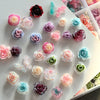A collection of colorful 3D floral butterfly pearl nail art charms in various shades of pink, purple, blue, and green.