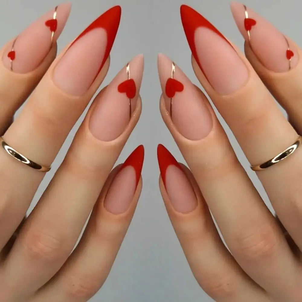 A close-up of a hand displaying red and nude press-on false nails with a French wavy design.