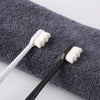 A black and white ultra-fine bristle toothbrush set resting on a gray towel.