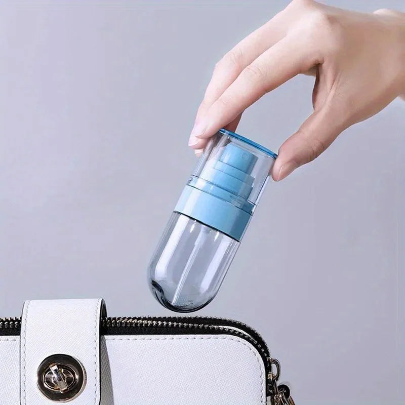 A hand is holding a clear glass mist spray bottle with a blue cap above a white zippered purse.