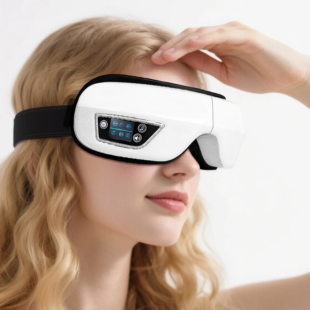 A woman is using a white portable Bluetooth eye massager with vibration and music on her eye.