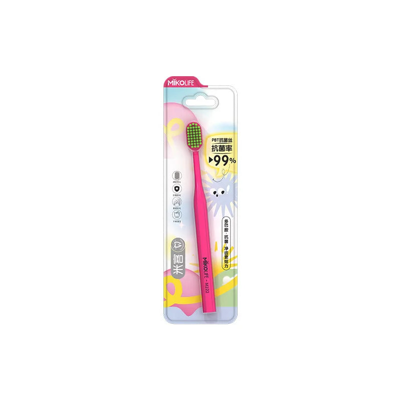 A pink soft bristle manual toothbrush packaged in a clear plastic container.
