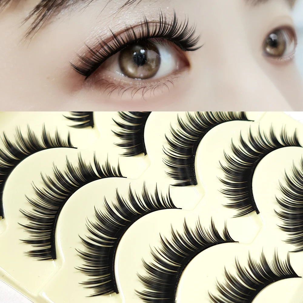 A close-up of a pair of long, thick black false eyelashes on an eye, next to a palette of eyelash strips.