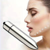 A woman applying a facial eye massager to her face for lotion absorption.