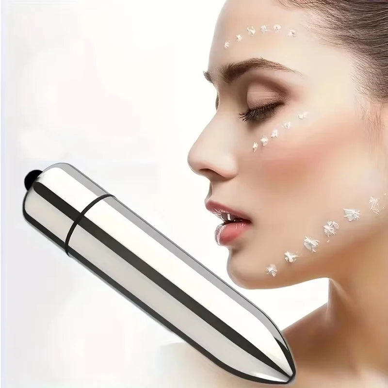 Una mujer aplica gotas de masaje facial en su rostro usando una herramienta mini plateada para absorber loción.