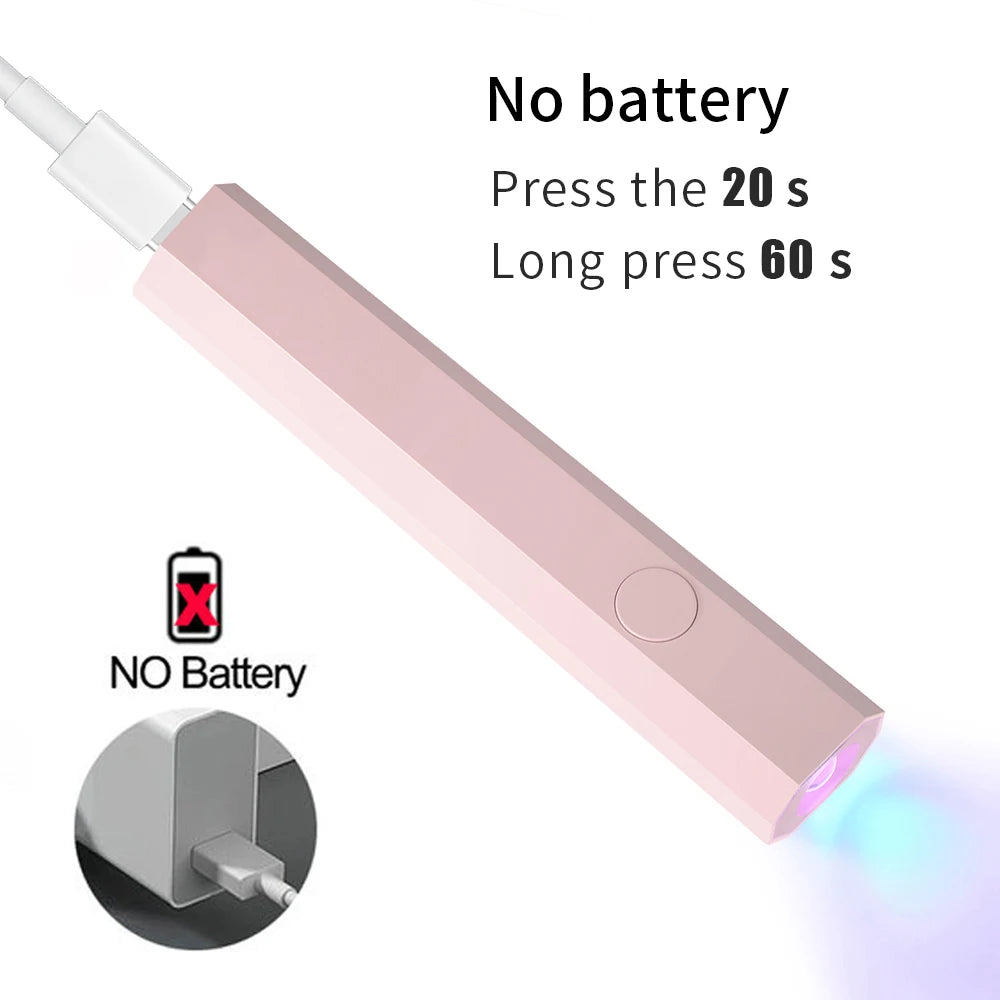 A pink portable UV nail dryer lamp with a white connector, showing instructions for battery usage.