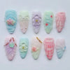 Un set de 10 uñas postizas de mariquita verde fresca en 3D con varios acabados pastel e iridiscentes.