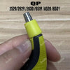 A hand holds a yellow and black beard shaver replacement blade with a silver tip against a wooden background.