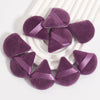 Un ensemble de puffs triangulaires violets avec des rubans satinés sur une surface blanche.