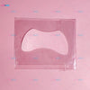 A clear silicone lash lift shield eye pad with a pink glittery cosmetic product inside.
