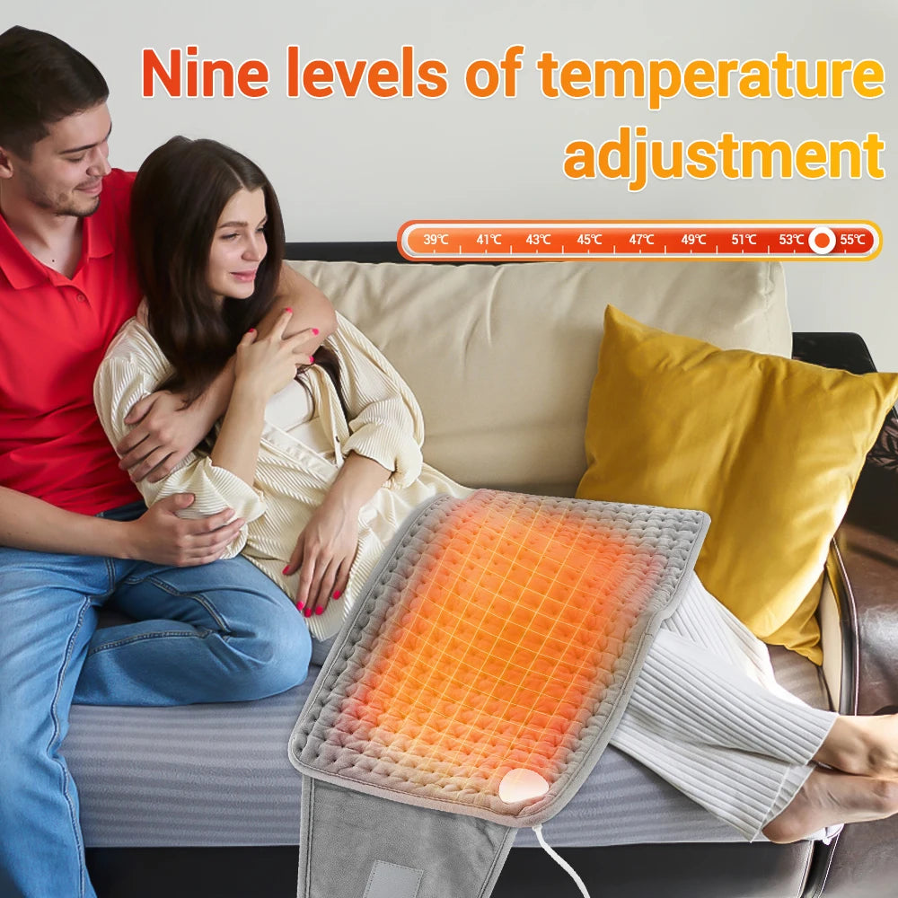 A woman is using an electric heating pad on her abdomen while sitting on a couch.