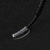 A close-up shot of a disposable micro brush for eyelash extensions resting on a dark surface.