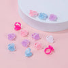 A collection of pink and blue disposable glue rings for eyelash extensions and nail art displayed on a white surface.