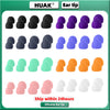 A collection of various colored silicone ear tips and plugs displayed on a green background.