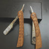 Un par de maquinillas de afeitar manuales profesionales de madera con mangos texturizados y cuchillas plateadas, sobre una su