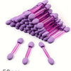 A pile of purple and pink double-sided nail art brushes with sponge applicators.