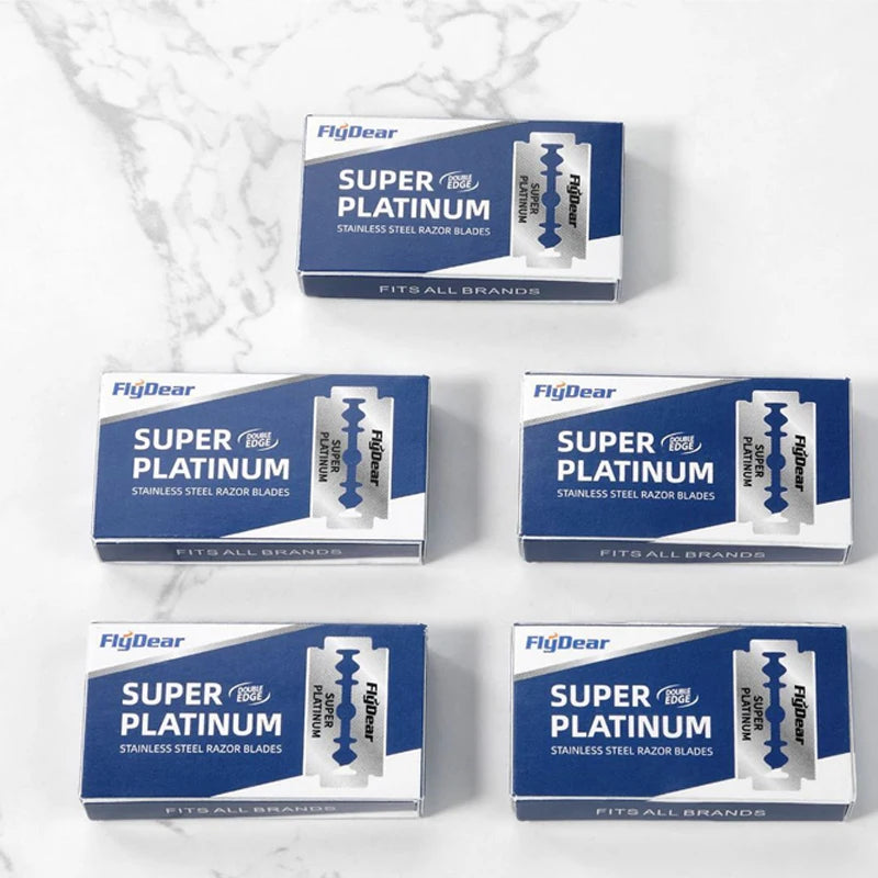 Tres cajas de cuchillas de afeitar de acero inoxidable FlagDear Super Tool Platinum expuestas sobre una superficie de mármol 
