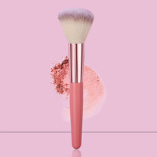 A pink face powder brush with a fluffy white synthetic hair and loose pink powder surrounding the handle.