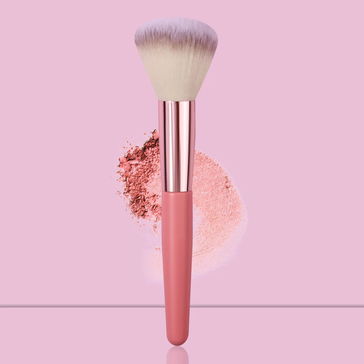 A pink face powder brush with a fluffy white synthetic hair and loose pink powder surrounding the handle.
