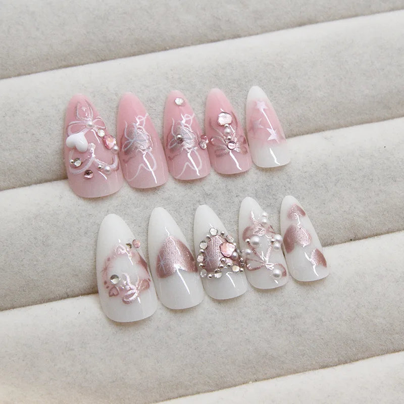 A set of 24 pink heart pearl press-on fake nails displayed on a white background.