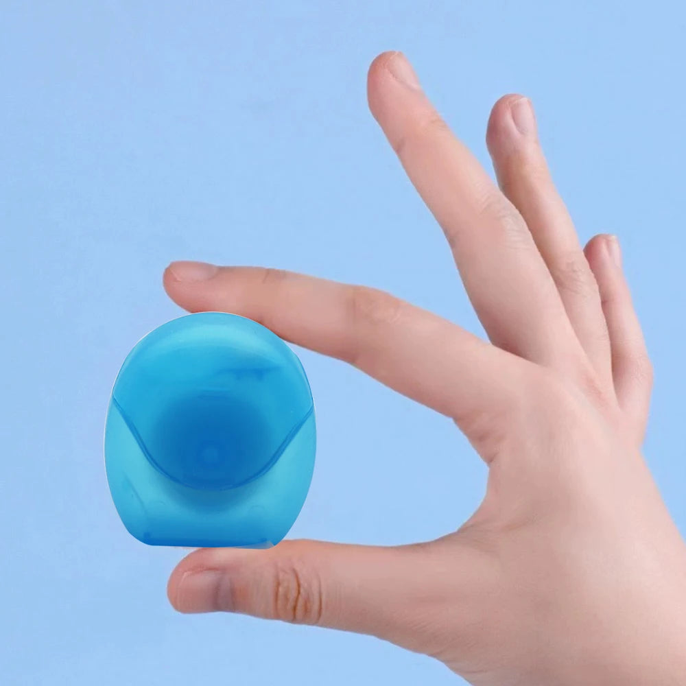 A hand holds a small, light blue reusable dental floss threader device against a pale blue background.