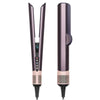 A vertical, rose gold hair straightener with a black handle and mesh base.