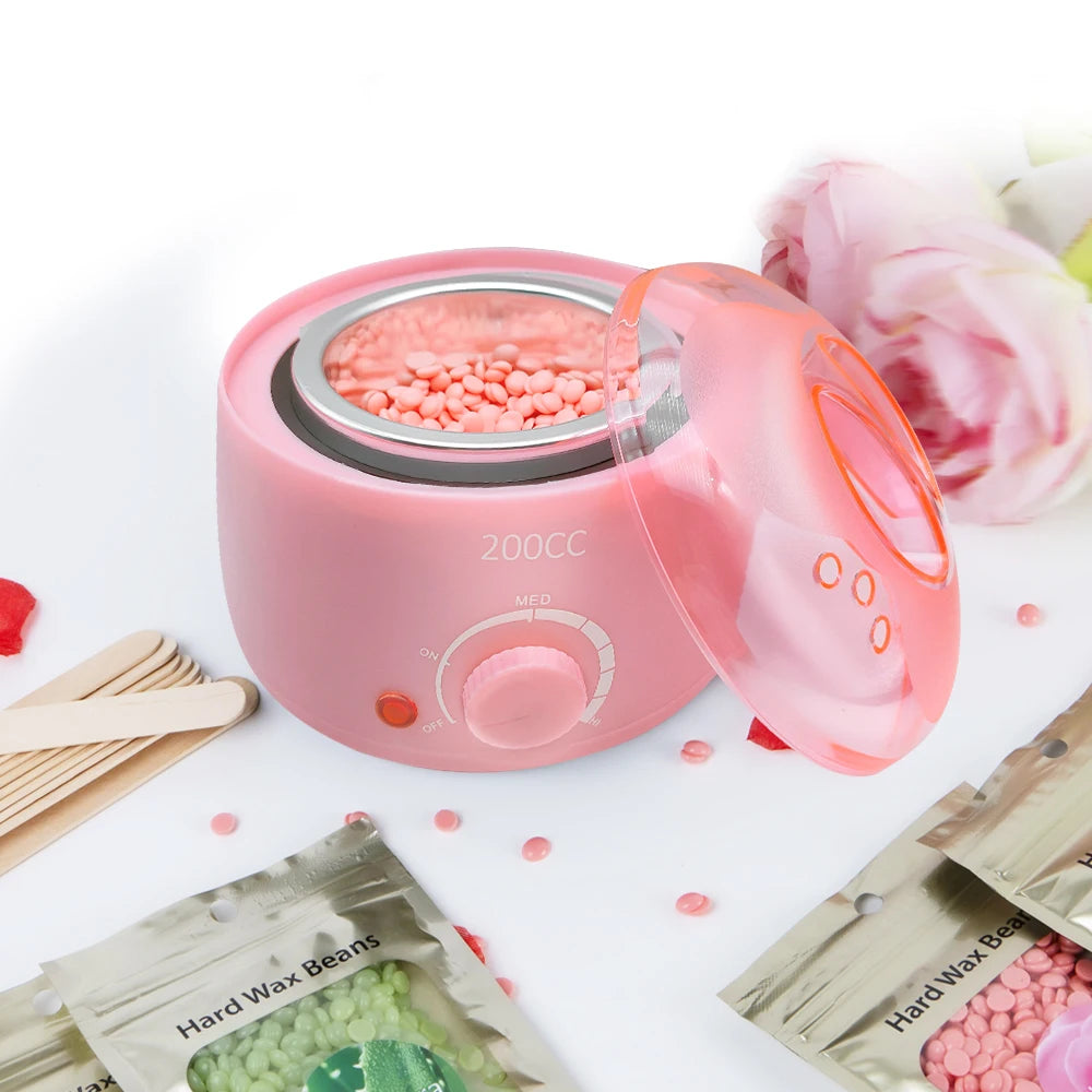Ein rosa Paraffinwachthitzegerät neben losen Wachsstangen und Holzstäbchen