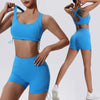Una mujer modela un conjunto deportivo de yoga y gimnasio azul brillante, transpirable y de secado rápido, con top y shorts.