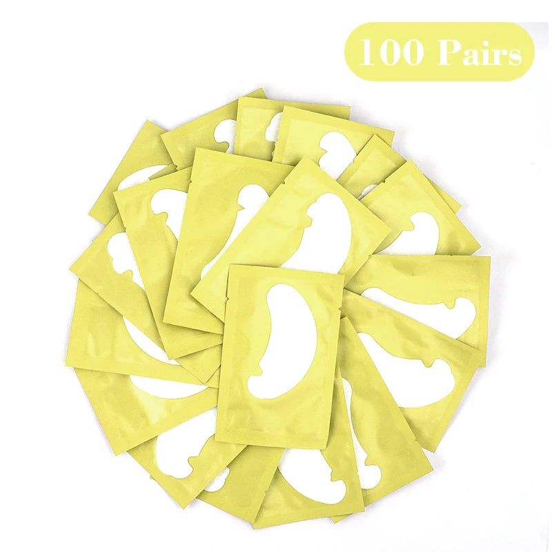 Collection de 100 paires de pads en hydrogel jaunes pour extensions de cils, disposés en cercle.