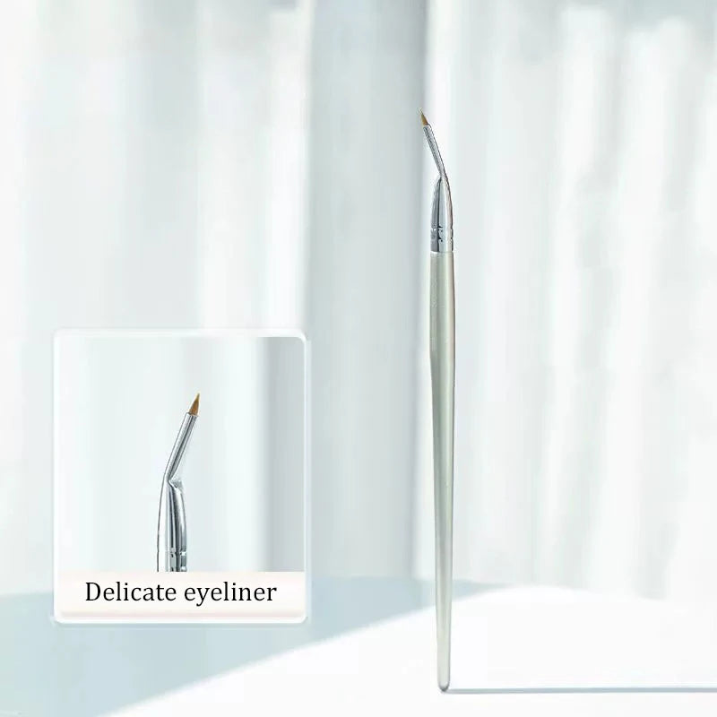 A close-up view of a silver angled eyeliner brush against a white background.