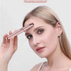 A woman is using a pink precision electric eyebrow trimmer to shape her eyebrows.