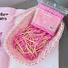 Un contenant rose contient un paquet de cotons-tiges en bambou rose pour un nettoyage doux.