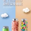 Glass jars filled with pink and green earplugs for sound insulation technology